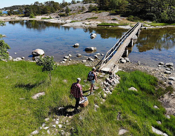 Two persons about to cross a wooden bridge on the archipelago national park