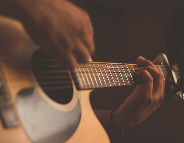 A close up of a person playing a guitar