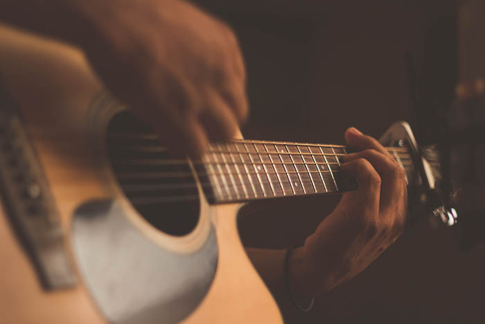 A close up of a person playing a guitar