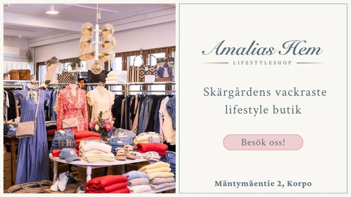 Interiör i en livsstilsbutik med prydligt arrangerade kläder, accessoarer och inredningsartiklar; skylten "Amalias Hem" inbjuder besökare till butiken i Korpo.