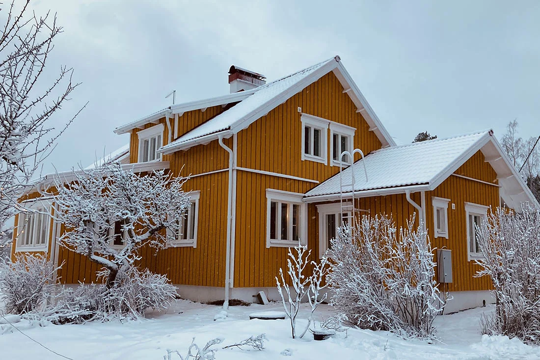 Kaunis keltainen talo Korpossa lumen alla
