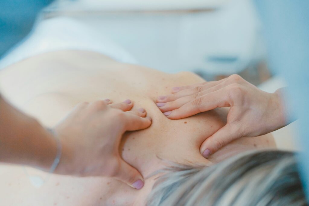 En terapeut utför en ryggmassage på en klient i en spamiljö.