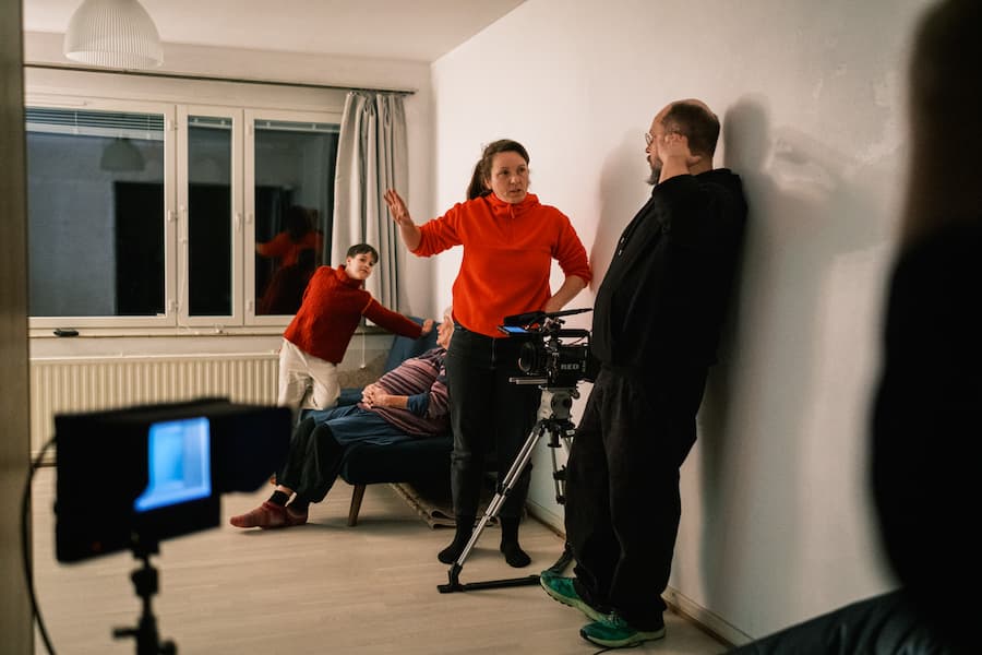 Fyra varg/män i solglasögon, skinnjackor och jeans står på en träscen 